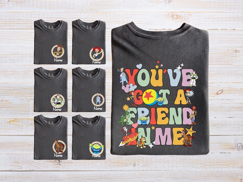 A collection of gray t-shirts with various cartoon character designs and text, along with a t-shirt featuring a colorful, playful design with the text "You've Got a Friend in Me".