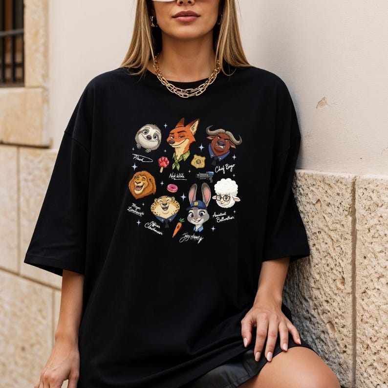 A woman wearing a black t-shirt with a graphic design of various cartoon animal characters, including a lion, a unicorn, and other animals.