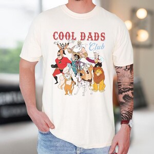 A person wearing a white t-shirt with a graphic design featuring various cartoon characters, including a lion, a dog, and other animals.