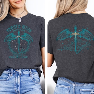 a woman wearing a gray t-shirt with a graphic design on the back. The design includes a dragon and a sword, along with the text "Fourth of July War College".