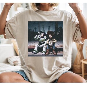 a person wearing a t-shirt with a printed image of two people sitting on a bench.