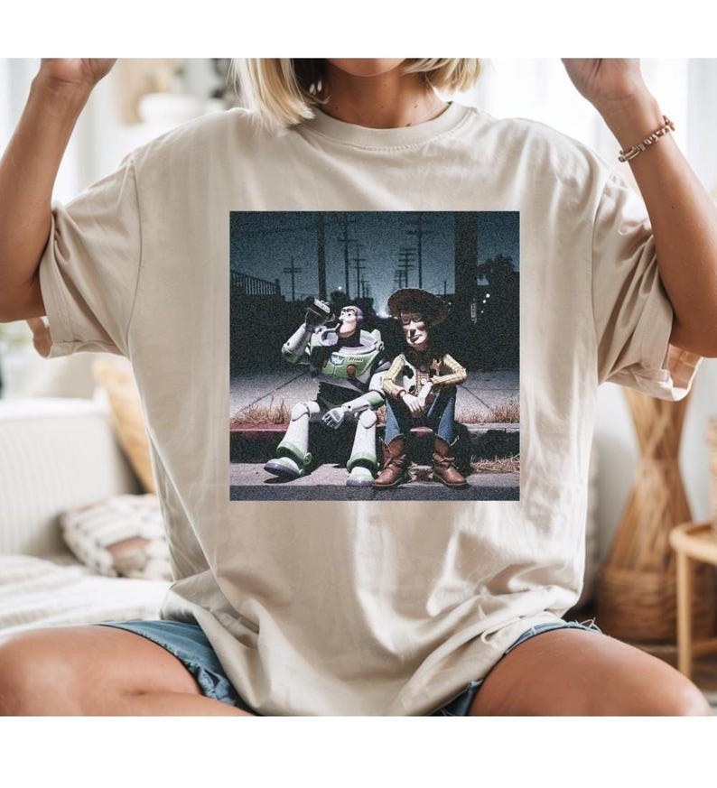 a person wearing a t-shirt with a printed image of two people sitting on a bench.