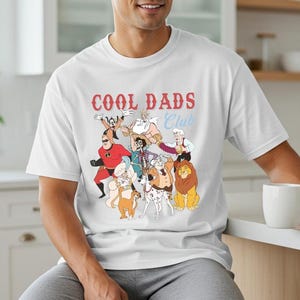 A man wearing a white t-shirt with a graphic design of cartoon characters and text.