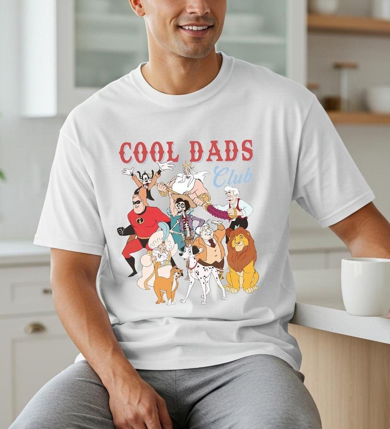 A man wearing a white t-shirt with a graphic design of cartoon characters and text.