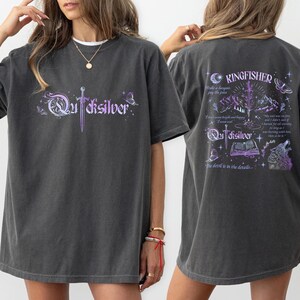 a woman wearing a gray t-shirt with a graphic design on the front and back.