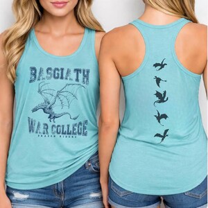 A woman wearing a teal tank top with a graphic of a dragon and the text "BASGIATH WAR COLLEGE DRAGON RIDERS" printed on it.