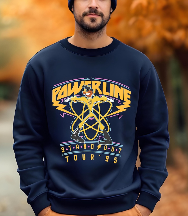 May include: A navy blue sweatshirt with a yellow cartoon character in a superhero pose. The text "POWERLINE STAND OUT TOUR '95" is printed on the front of the sweatshirt.