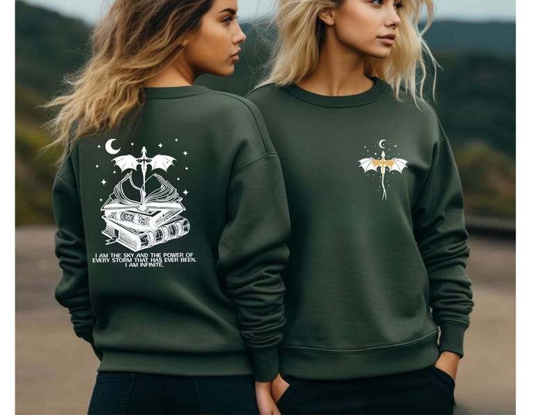 Two women wearing green sweatshirts with a dragon design and text on the back.