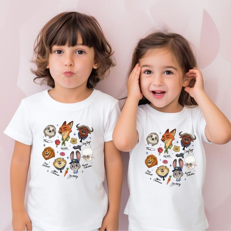 Two young children wearing white t-shirts with various cartoon animal characters printed on them.
