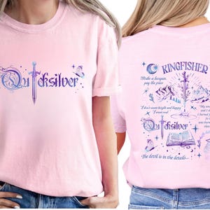 a woman wearing a pink t-shirt with a design and text on it.