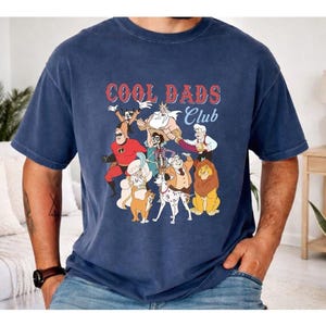 A man wearing a blue t-shirt with a graphic design featuring various cartoon characters, including a lion, a dog, and other animals.