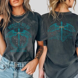 two women wearing black t-shirts with a dragon design on the back.