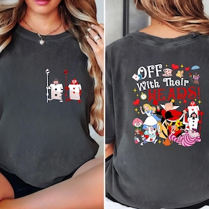 May include: A dark gray t-shirt with a graphic of the Queen of Hearts and other characters from Alice in Wonderland. The text "Off With Their Heads!" is printed on the back of the shirt.