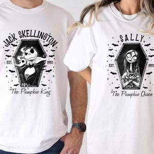 Pu&ograve; includere: T-shirt bianche con illustrazioni in bianco e nero di Jack Skellington e Sally da Nightmare Before Christmas. Ogni disegno &egrave; a forma di bara con il testo "Jack Skellington" e "Sally" sopra i personaggi, con "The Pumpkin King" e "The Pumpkin Queen" sotto.