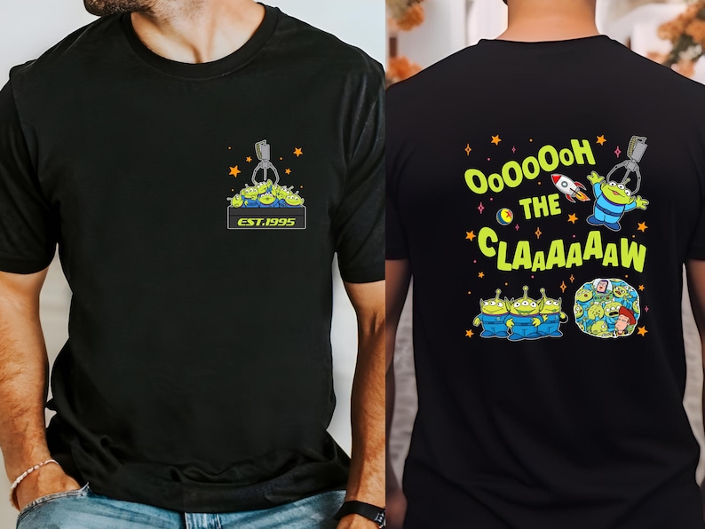 Pu&ograve; includere: Due magliette nere a tema Toy Story. La parte anteriore di una maglietta presenta una macchina a graffe con alieni verdi all'interno e il testo "EST. 1995". La parte posteriore dell'altra maglietta presenta un alieno verde con un razzo e il testo "Oooooh the Claaaaaaw".