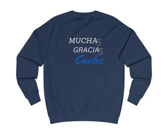 May include: A navy blue sweatshirt with the text "MUCHA 5 GRACIAS 5 Carlos" printed on the back in white and blue.