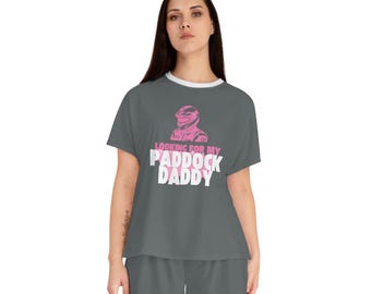 Puede incluir: Conjunto de pijama gris con un gráfico rosa de una persona con casco y el texto "Looking for my Paddock Daddy".