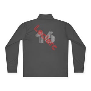 May include: A dark gray long-sleeve shirt with a red and white graphic design that says "Leclerc 16" on the back.
