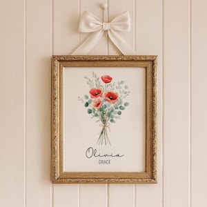 Puede incluir: Una impresi&oacute;n floral enmarcada con un ramo de acuarela de amapolas rojas y follaje verde, atado con hilo. La impresi&oacute;n est&aacute; en un marco dorado adornado y est&aacute; suspendida por un lazo color crema. Los nombres "Olivia" y "Grace" est&aacute;n escritos en cursiva.
