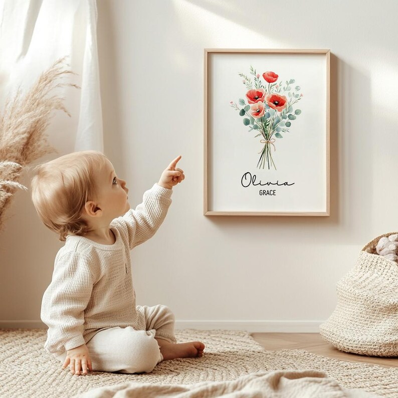 Puede incluir: Una impresi&oacute;n art&iacute;stica floral enmarcada con un ramo de acuarela de amapolas rojas y follaje verde, atado con hilo. La impresi&oacute;n incluye los nombres "Olivia" y "Grace" en una elegante escritura. La obra de arte se exhibe en una pared clara.