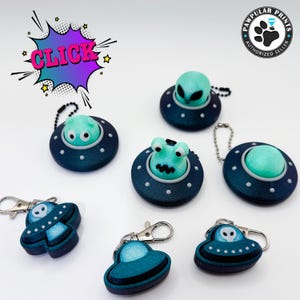 May include: Six green alien keychains with blue and white spaceship designs. The keychains feature different alien designs, including a classic alien head, a green alien with eyes, and a green alien with a mouth. The keychains are perfect for adding a fun and quirky touch to your keys or bag.
