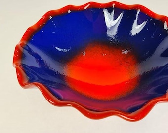 Kom van gesmolten glas in kobaltblauw met een gloeiend oranje midden en rand.