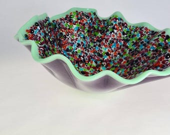 Levendige kom van gesmolten glas met schitterende transparante bolletjes die glinsteren tegen een mintgroene rand.