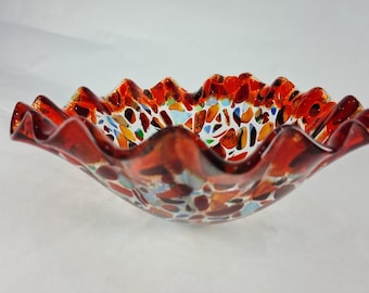 Gesmolten glazen schaal met veelkleurige glaskiezels en levendige oranje halo
