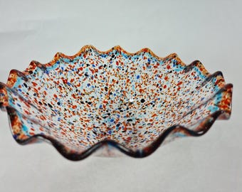 Fijne gecanneleerde glazen kom gespikkeld met levendig oranje en helderblauw