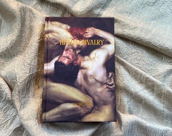 May include: A book titled "Heated Rivalry" with a Renaissance-style painting on the cover, featuring two figures in a passionate embrace. The book's cover is a dark, rich color, and the title is in gold lettering.