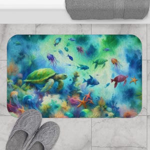 Puede incluir: Alfombra de baño rectangular con una escena submarina con una tortuga marina verde, peces coloridos, medusas y estrellas de mar. La alfombra tiene un diseño de estilo acuarela con tonos de azul, verde y coral.