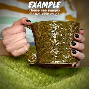 May include: A green ceramic mug with a textured, leafy design. The mug has a unique, curved handle.