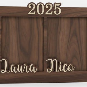 May include: A wooden double photo frame with the year "2025" at the top. The frame has two openings and the names "Laura" and "Nico" are displayed at the bottom. The frame is made of dark brown wood.