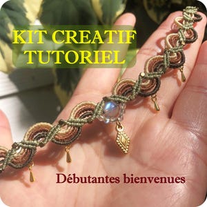 以下が含まれることがあります： 茶色、ベージュ、オリーブグリーンの手作りのマクラメブレスレット。小さな金色のビーズと涙型のチャームで飾られています。ブレスレットの中央には虹色のビーズとひし形のチャームがあります。画像には「KIT CREATIF TUTORIEL」と「Débutantes bienvenues」という文字が含まれています。