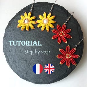 May include: A close-up of a pair of yellow and red flower earrings with a pearl bead in the centre of each flower. The earrings are on a black slate background with the text "TUTORIAL Step by step" and French and British flags.
