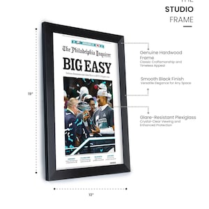 May include: A black framed print of a newspaper article from The Philadelphia Inquirer with the headline "BIG EASY". The article is about the Philadelphia Eagles winning the Super Bowl. The frame is 19 inches tall and 13 inches wide.