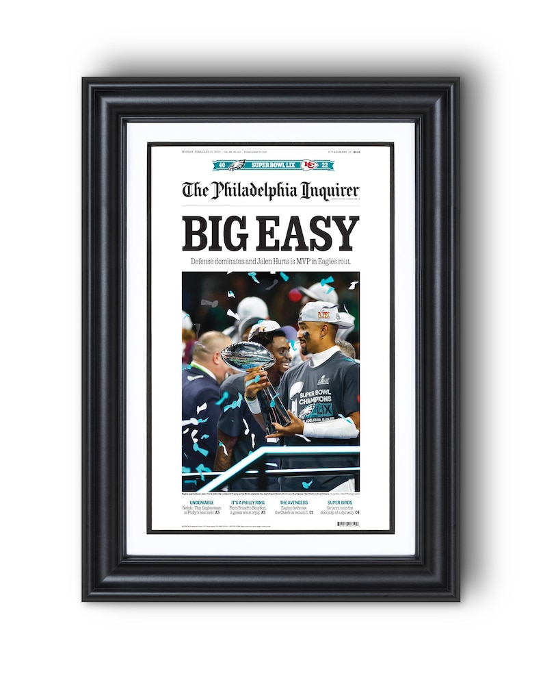 May include: A newspaper front page with the headline "BIG EASY" in bold, black font. The Philadelphia Inquirer logo is above the headline. The sub-headline reads "Defense dominates and Jalen Hurts is MVP in Eagles rout." A photo of Jalen Hurts holding the Super Bowl trophy is in the center of the page.