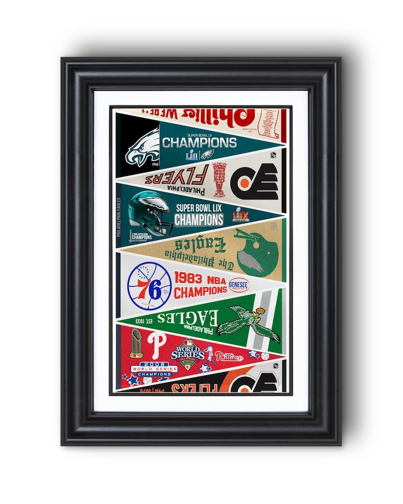 May include: Framed print featuring pennants celebrating Philadelphia sports teams. Includes the Eagles, Flyers, Phillies, and 76ers. Each pennant displays team logos, championship years, and the words "Champions" and "World Series". The frame is black.