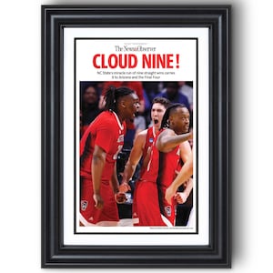 May include: Framed print featuring a sports photograph. The image shows basketball players in red uniforms celebrating. The headline reads "CLOUD NINE!" with text about NC State's winning streak. The frame is black.