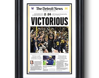 May include: A newspaper headline from The Detroit News announcing the Michigan Wolverines victory in the 2024 CFP National Championship. The headline reads "VICTORIOUS" with confetti falling on the team celebrating in the background.