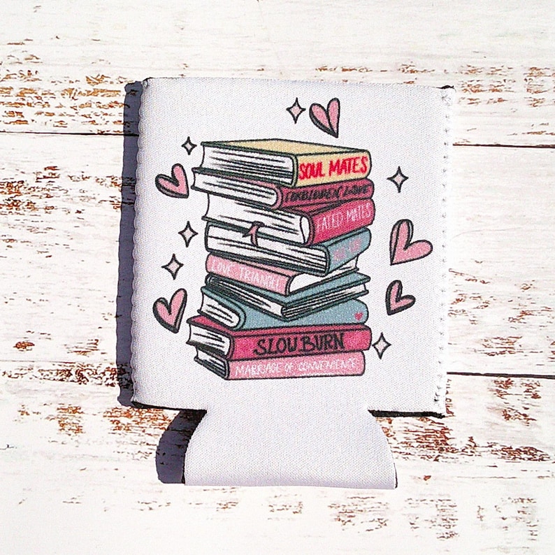 May include: White can cooler with a stack of books with titles like "Soul Mates", "Forbidden Love", "Fated Mates", "Love Triangle", and "Slow Burn" with pink hearts around the books.