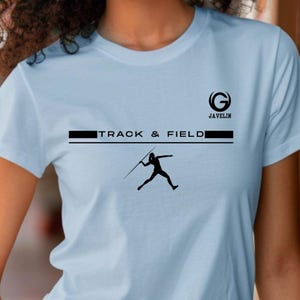 May include: Light blue t-shirt with a black graphic of a javelin thrower and the words "TRACK & FIELD". The shirt also features the word "JAVELIN" and a stylized "G" logo.