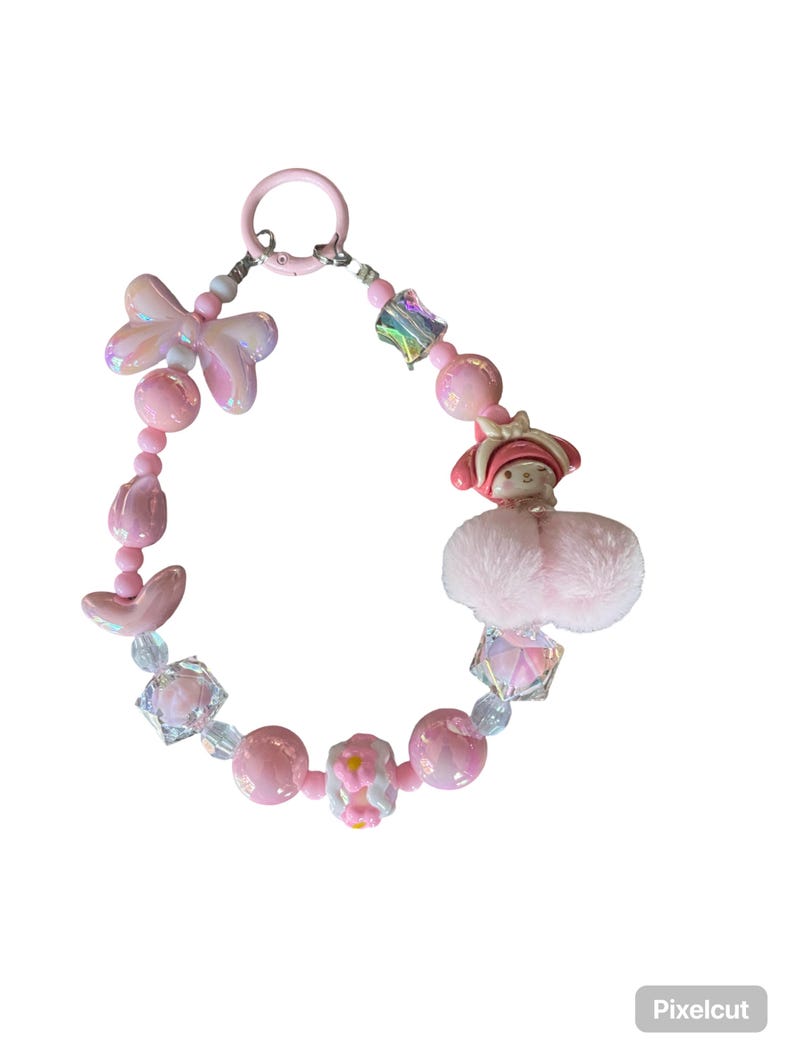 Pu&ograve; includere: Un portachiavi rosa con perline con una variet&agrave; di perline, tra cui perline iridescenti a forma di fiocco, perline di cristallo sfaccettate e perline rosa rotonde. &Egrave; incluso anche un piccolo personaggio rosa con un cappello rosso e un soffice pompon rosa.