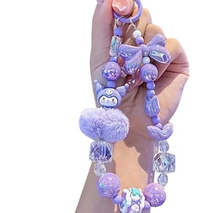 Pu&ograve; includere: Un portachiavi con perline viola con una variet&agrave; di elementi decorativi. Il portachiavi presenta un soffice pompon, un personaggio dei cartoni animati, un fiocco e varie perline nelle tonalit&agrave; del viola e del trasparente. Il portachiavi &egrave; tenuto da un anello viola.