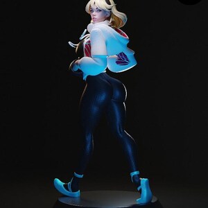 K&ouml;nnte beinhalten: Figur einer weiblichen Figur in dynamischer Pose, mit wei&szlig;er Jacke mit roten Akzenten und lila Blattmuster. Sie tr&auml;gt schwarze Leggings und blaue Schuhe. Der Sockel ist schwarz, der Hintergrund dunkel. Blondes Haar.