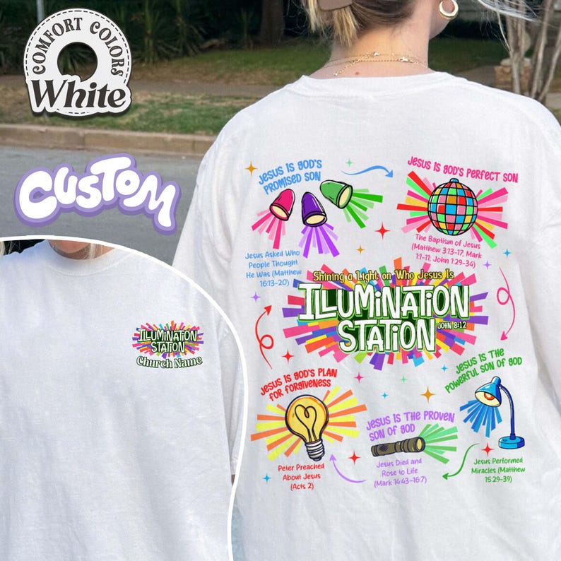 May include: White t-shirt with colorful graphics and text. The shirt features the words "ILLUMINATION STATION" and various religious phrases and illustrations. The design includes a light bulb, a globe, and other symbols.