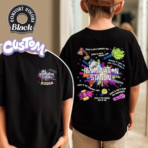 May include: Black t-shirt with the text "ILLUMINATION STATION" and "JESSICA" on the front. The back of the shirt features the text "JESUS IS GOD'S PROMISED SON" and other religious phrases with colorful graphics.