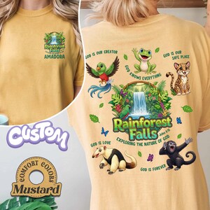 May include: Mustard-coloured t-shirt with a Rainforest Falls graphic on the front and back. The back features a waterfall scene with various animals and the text "God is our Creator," "God is Love," and "God is Forever."
