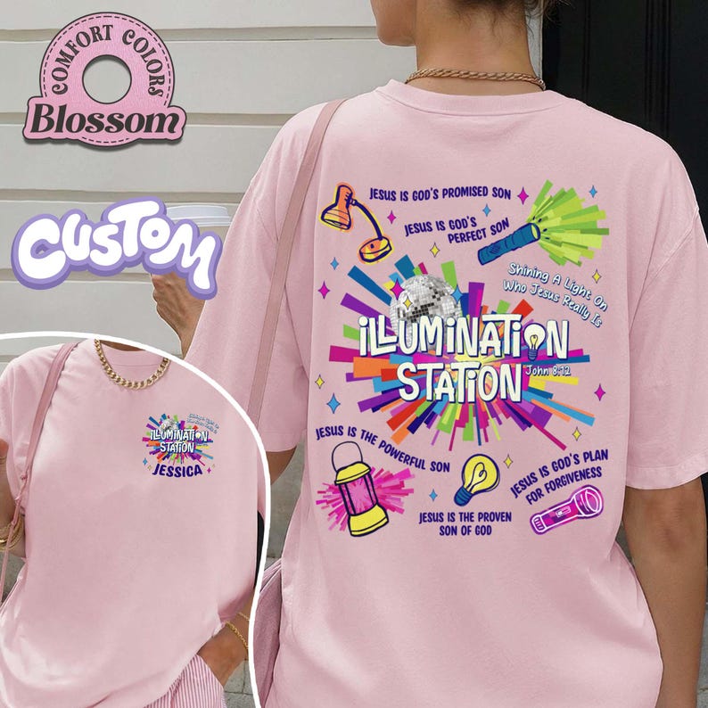 May include: A light pink t-shirt with the text "ILLUMINATION STATION" and various graphics. The back of the shirt features a colorful design with religious text and illustrations. The front of the shirt has a smaller version of the design with the name "JESSICA".
