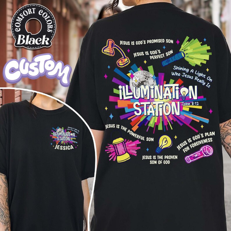 May include: Black t-shirt with a colorful graphic design. The design includes the words "ILLUMINATION STATION" and various religious phrases and illustrations. The shirt also features the text "John 8:12".